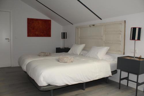 塞维利亚COZY & MODERN APARTMENT HOMBRE DE PIEDRA的一间卧室配有一张带两盏灯的大型白色床。