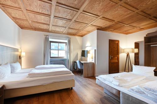 慕尼黑Hotel Schleuse的卧室设有两张床铺和木制天花板