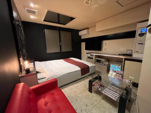 旭川旭川ホテル818-大人専用的一间卧室配有一张床和一张红色的沙发