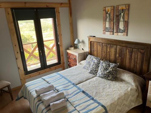 霍约斯德尔埃斯皮诺Cara norte de Gredos的卧室配有带枕头的床铺和窗户。