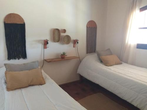 蒂尔卡拉Casona Inkill Huasi II的带2张床的客房,位于带窗户的房间内