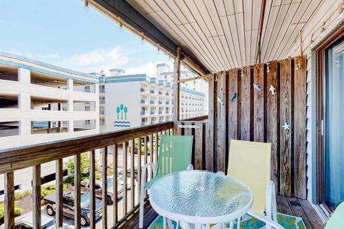 大洋城Seaward Villas 301的阳台配有桌椅。