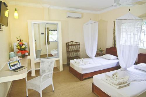 西哈努克日落休闲酒店的酒店客房,设有两张床和镜子