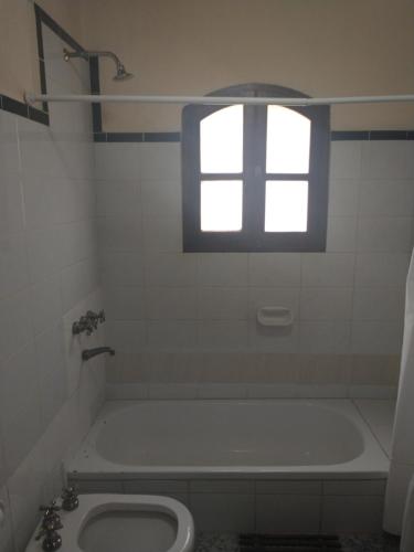 蒂尔卡拉Casona Inkill Huasi II的带浴缸、卫生间和窗户的浴室