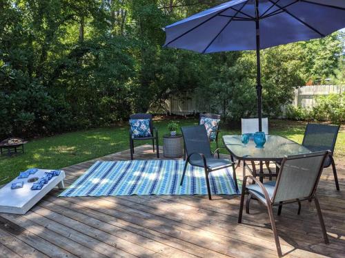 威尔明顿Wilmington Family Vacation Home的庭院配有桌椅和遮阳伞。