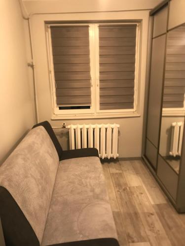 RaczkiApartament, noclegi na doby - Raczki k. Suwałk的窗户和暖气间的一张床位