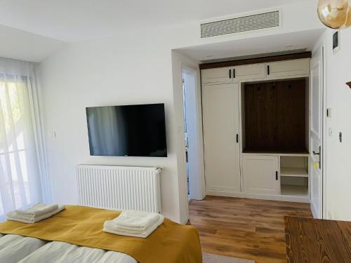 克利默内什蒂Hanul cu Sălcii的白色的客房配有床和平面电视。