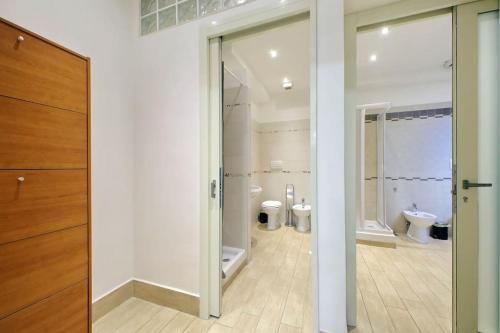 罗马Vatican Flat Spacious Cozy with Court的浴室设有2个卫生间和滑动玻璃门