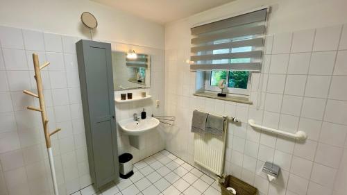 霍鲁梅尔希尔Ferienwohnung Südhoff的一间带水槽和卫生间的浴室以及窗户。