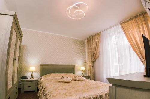 比斯特里察HOTEL CORA Bistrita的一间卧室配有一张床和一个吊灯