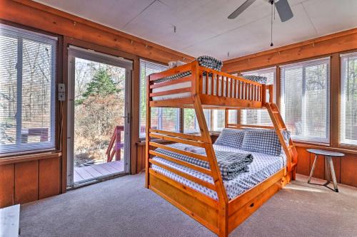 东斯特劳兹堡Dog-Friendly Pocono Mtns Cabin with Deck Near Hiking的带窗户的客房内设有一间带双层床的卧室