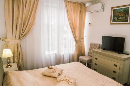 比斯特里察HOTEL CORA Bistrita的一间卧室设有一张床、一台电视和一个窗口。