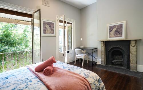 悉尼Kent Terrace的一间卧室配有一张带壁炉和书桌的床。