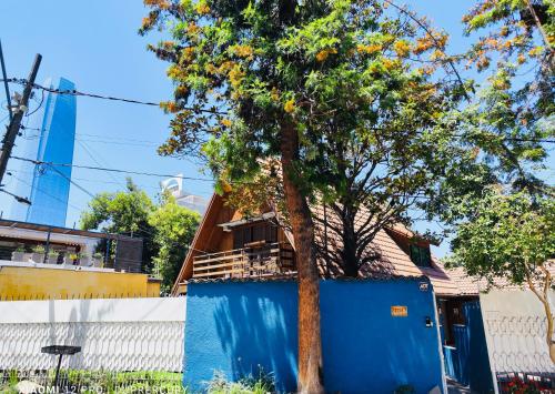 圣地亚哥Maktub Costanera - Hostal Boutique的蓝墙房子前面的树