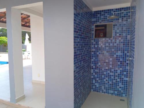 塞古罗港APARTAMENTO 3 quartos no Taperapuan Duplex 450 mt da praia的浴室设有蓝色瓷砖淋浴和一台电视。