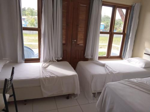 塞古罗港APARTAMENTO 3 quartos no Taperapuan Duplex 450 mt da praia的带2扇窗户的客房内的2张床
