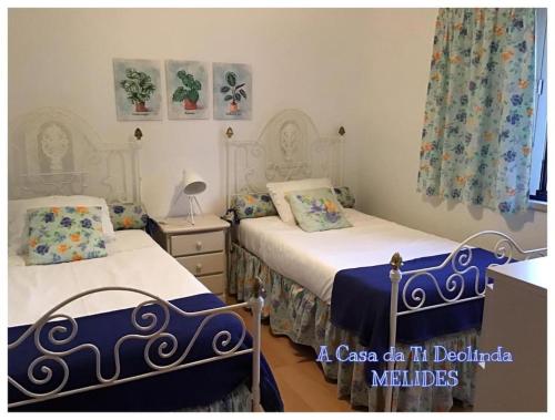 梅利迪什A Casa da Ti Deolinda的一间卧室配有两张带蓝白色床单的床