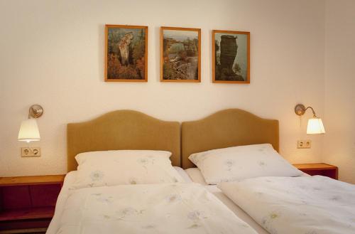 利希滕海恩利希滕海恩伯格霍夫酒店的卧室配有两张床,墙上有三幅画
