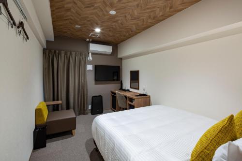 福冈Hotel Reference Tenjin III的一间卧室配有一张床、一张书桌和一台电视