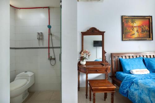库塔Graha Wedha Suite Kuta by kamara的浴室设有床、卫生间和水槽。