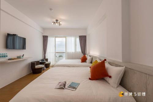 盐寮瞰海民宿的酒店客房设有两张床和电视。