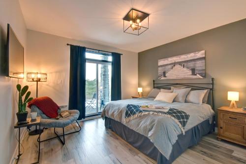 蒙特朗布朗Rental condo Tremblant-les-Eaux的卧室配有床、椅子和窗户。