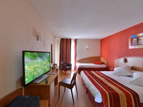 尼姆Kyriad Nîmes Ouest A9的酒店客房设有两张床和一台平面电视。