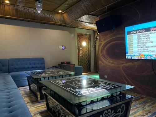 马尼拉MAH Resort by Cocotel的一间设有两张桌子和屏幕的等候室