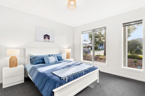 卡尔斯The Seas at Phillip Island的一间白色卧室,配有床和2个窗户