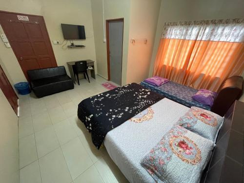 Kampong Alor GajahIkhlas Roomstay的一间设有床铺和沙发的房间