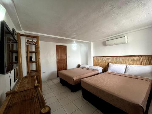 达拉盖地Ocean Bay Beach Resort的酒店客房设有两张床和电视。