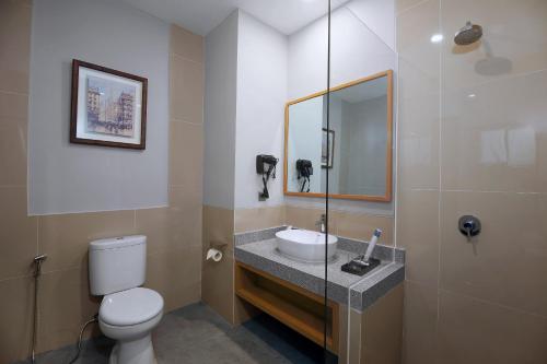 MojokertoASTON Mojokerto Hotel & Conference Center的一间带水槽、卫生间和镜子的浴室