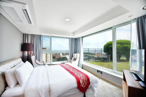 西归浦市巴雷福酒店的一间卧室设有一张床和一个大窗户