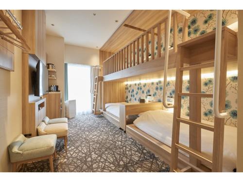 东京TOKYO EAST SIDE HOTEL KAIE的一间卧室配有两张双层床和电视