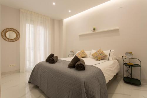 格拉纳达Apartamento San Isidro Centro的白色卧室,配有带毛巾的床