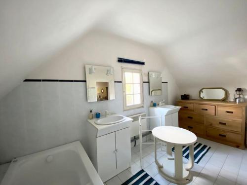 贝诺代Maison de famille près de la mer的白色的浴室设有两个盥洗盆和一张桌子
