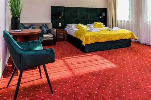 利岑Hotel Stara Gorzelnia的卧室配有1张床、1张桌子和1把椅子