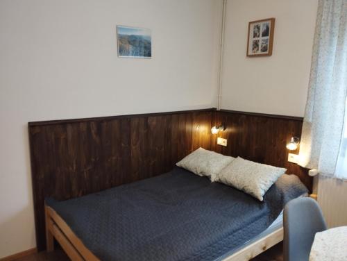 泽拜盖尼Börzsöny Vendégház的卧室内的一张带木制床头板的床