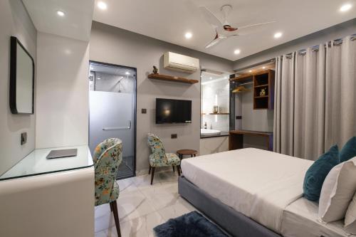 斋浦尔斋浦尔穆斯塔什旅舍的一间卧室配有一张床、一张书桌和一台电视。