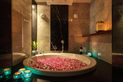 斋浦尔斋浦尔穆斯塔什旅舍的浴室设有装满粉色花瓣的大浴缸。