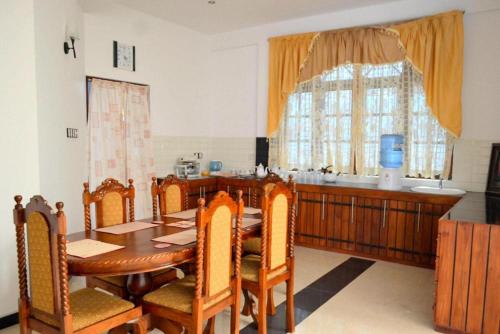 AmbalantotaSobaya Residence的一间带桌椅和窗户的用餐室