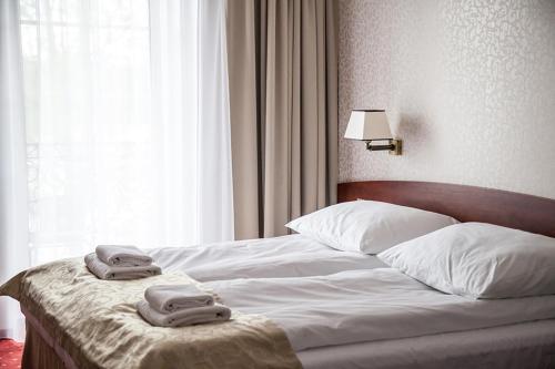 利岑Hotel Stara Gorzelnia的一间卧室配有一张床,上面有两条毛巾