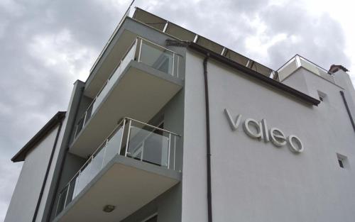 巴尔奇克Valeo Hotel的白色的建筑,上面有voda标志