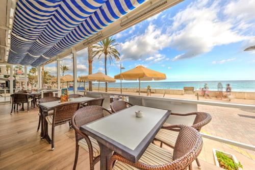 卡拉米洛沃拉玛酒店的一间带桌椅的餐厅,享有海滩美景
