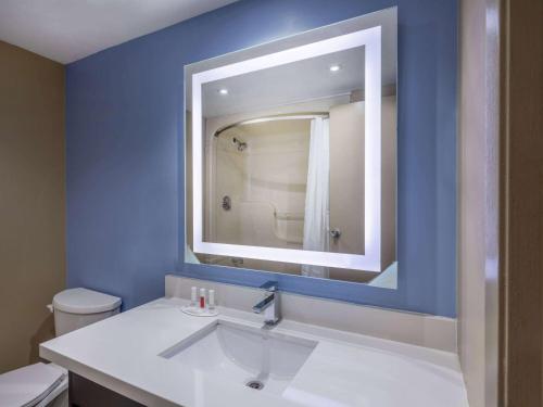 多伦多多伦多东速8酒店的蓝色的浴室设有水槽和镜子