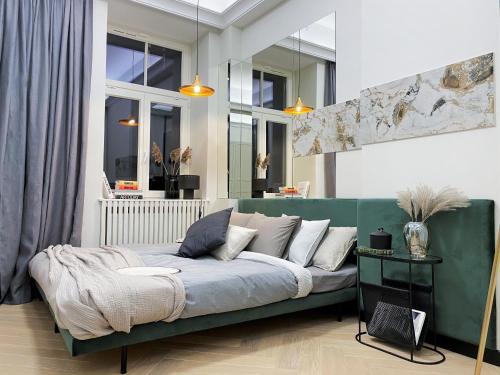 华沙AK Apartments的带窗户的客房内设有带绿色沙发的客厅