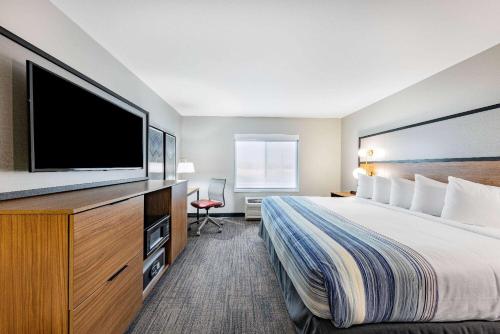 国际瀑布城AmericInn by Wyndham International Falls的配有一张床和一台平面电视的酒店客房