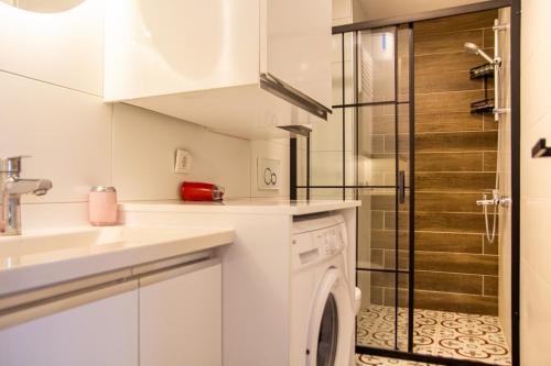 伊兹密尔Colorful and Central Flat near Kulturpark Izmir的白色的厨房配有洗衣机和淋浴。