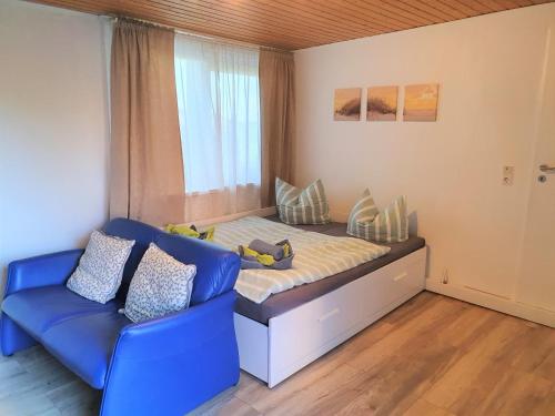 诺德代希Apartment Nordseeblick的一间小卧室,配有一张床和一张蓝色的沙发