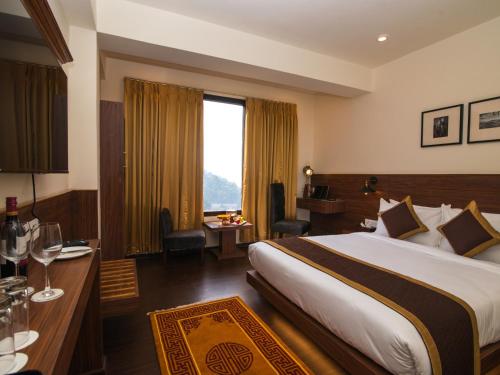 甘托克Indra Mandala,Gangtok - AM Hotel Kollection的酒店客房设有一张大床和一张书桌。